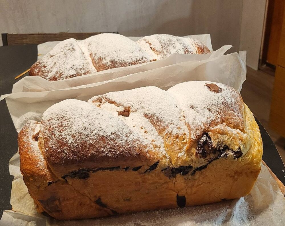 Cozonac pudrat cu zahăr, așezat în hârtie de copt