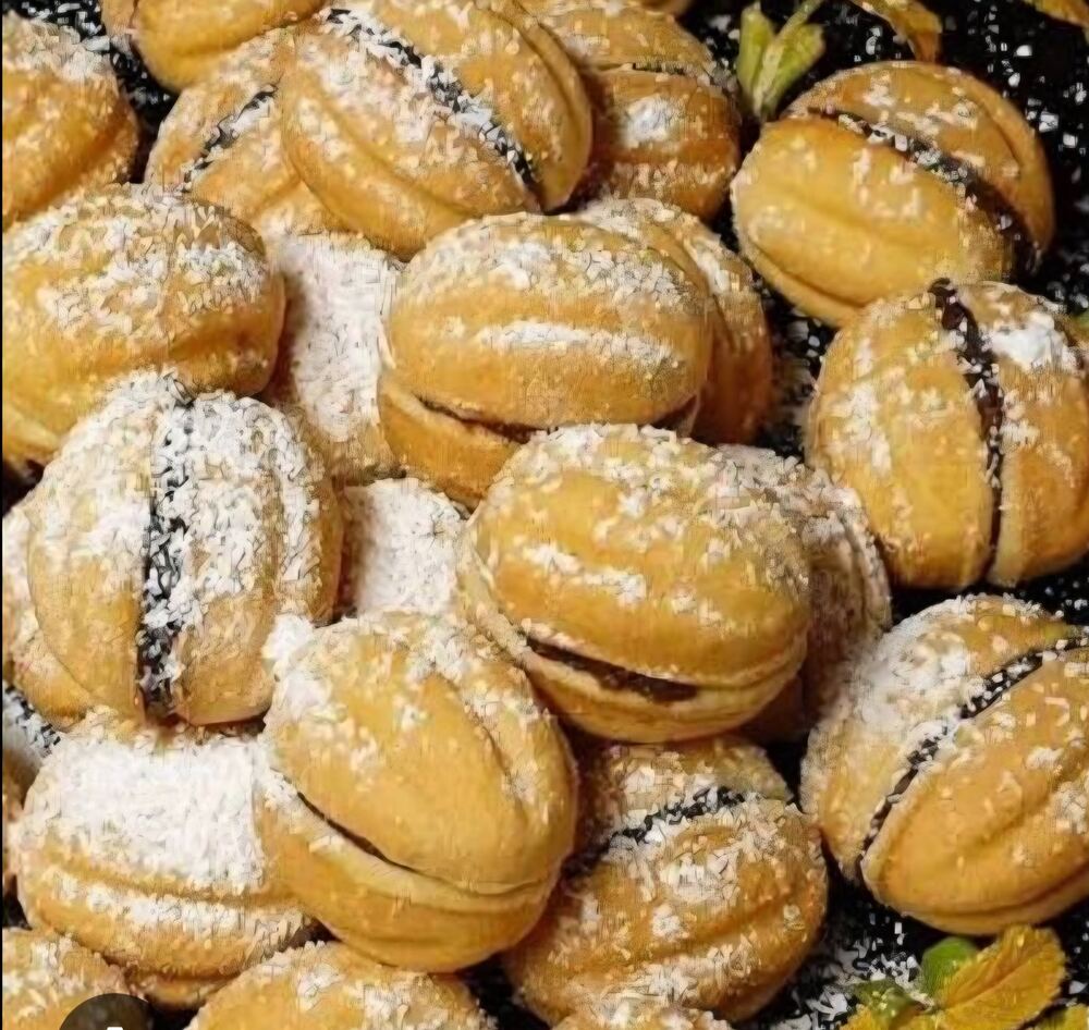 Nuci umplute pudrate cu zahăr, aranjate pe tavă