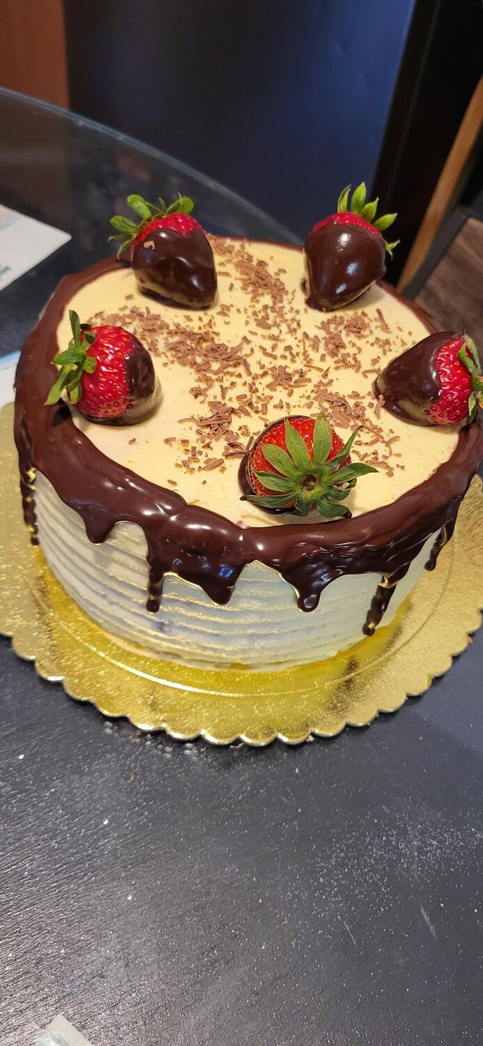 Tort cu cremă albă, glazură de ciocolată scursă pe margine și căpșuni în ciocolată deasupra